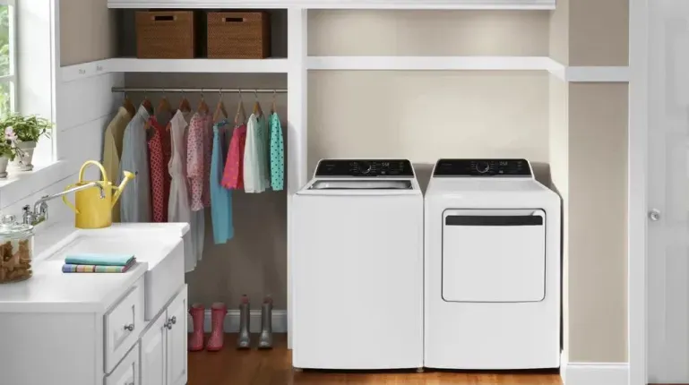 White Frigidaire top load washer FLVW7523BW and matching dryer set in a modern laundry room.